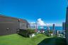 Rooftop terrace featuring synthetic turf, a built-in spa, glass railing, and expansive water and skyline scenery