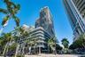 High-rise exterior featuring concrete structural design, tiered balconies with glass railings, and expansive floor-to-ceiling windows