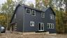 Construction Progress Photo of Exterior Siding Installation in Progress.
