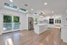 Kitchen featuring white cabinetry, central island with stone-finish countertop, stainless steel appliances, recessed ceiling lighting, and multiple sk