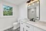 2nd floor Bathroom featuring a white vanity with a stone countertop, an integrated rectangular sink, matte black hardware, and patterned tile flooring