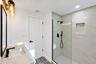2nd floor Bathroom featuring a stone-look countertop with an integrated rectangular sink, walk-in shower with large-format wall tile and built-in nich