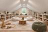 Vaulted ceiling featuring recessed lighting, extensive built-in white cabinetry with open shelving, and a central window with an integrated low-profil