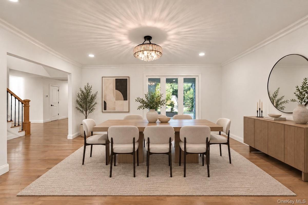 Dining area featuring wood-finish flooring, recessed lighting, crown molding, and a tiered crystal drum chandelier