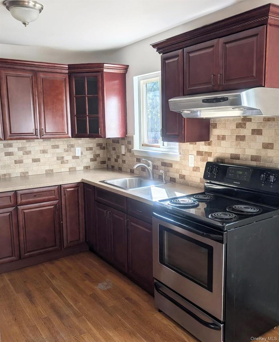 ...tile backsplash, solid-surface countertops, stainless steel undermount sink...