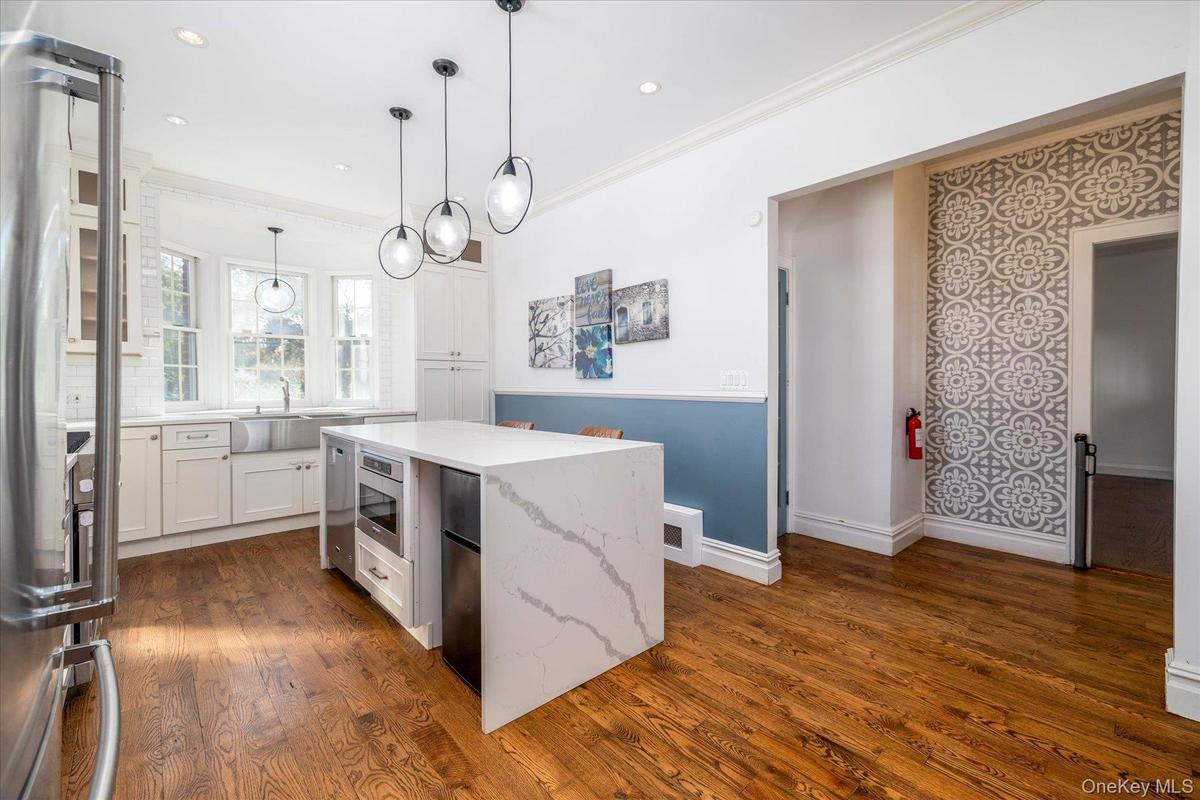 updated kitchen, center island with waterfall countertops and stainless steel appliances.