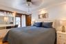 Tray ceiling with recessed lighting, ceiling fan, wood-finish flooring, built-in cabinetry, and decorative iron-detail exterior door
