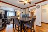 Dining area featuring wood-finish flooring, crown molding, and a central ceiling fan with integrated lighting