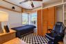 Bay window, built-in wooden shelving, dual-panel louvered closet doors, and a ceiling fan with integrated lighting