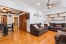 Open living area featuring wood-finish flooring, recessed lighting, ceiling fans, built-in wooden wall shelving, and wooden louvered closet doors