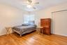 Wood-finish flooring, corner windows, and a ceiling-mounted fan with integrated light fixture