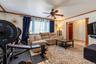 Multi-pane windows, wood-finish ceiling fan with integrated lighting, and decorative wood molding framing the entryway