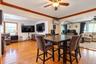 Wood-finish flooring, crown molding, ceiling fan with light fixture, mirrored wall accents, and recessed lighting