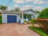 Front exterior with paver driveway, covered front porch, and attached garage