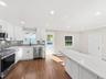 This gorgeous kitchen has a door leading to the yard, a step down to the den with access to garage for ease when coming home.
