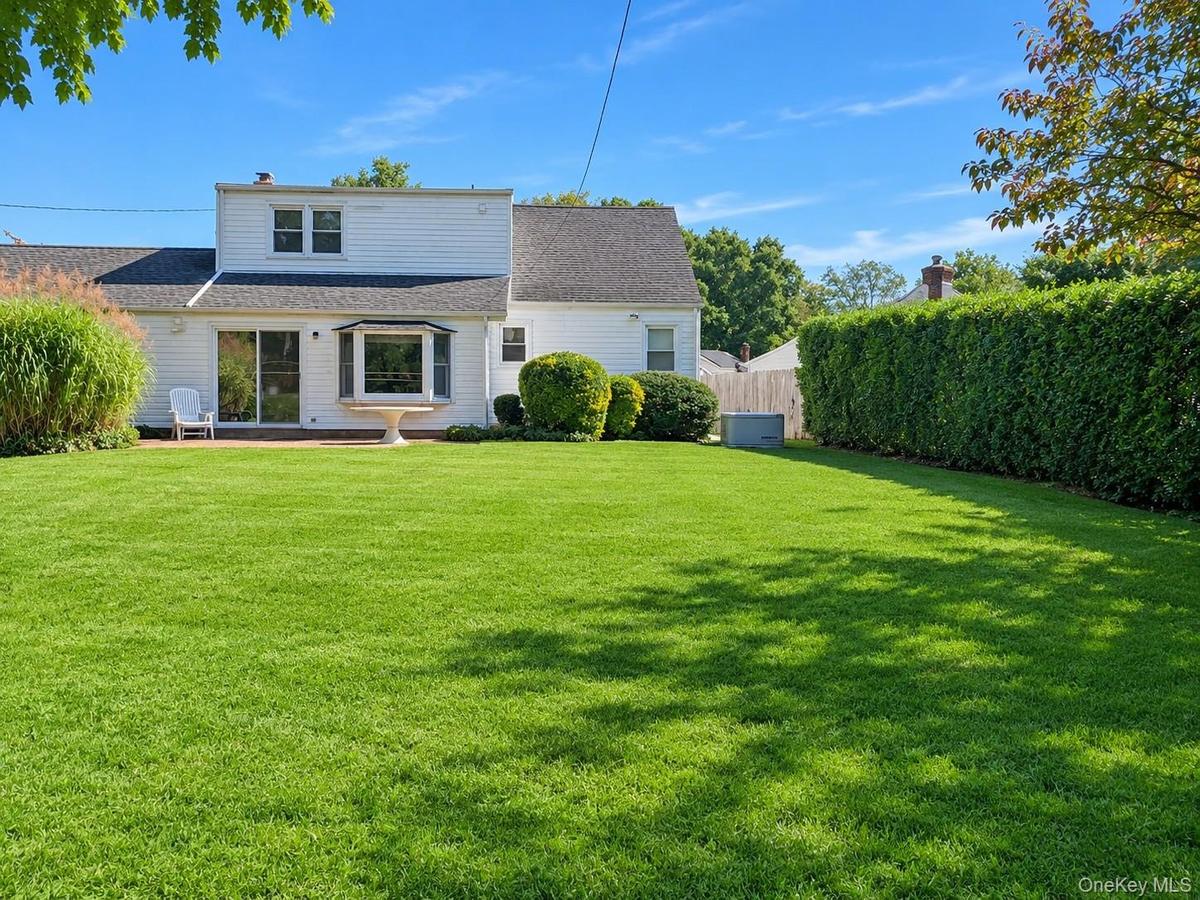 Expansive rear lawn with mature privacy hedging and established landscaping