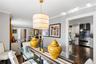 Neutral-toned interior featuring hardwood flooring, a cylindrical pendant light fixture, crown molding, and recessed lighting