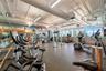 Fitness center featuring expansive floor-to-ceiling windows, exposed ductwork, recessed and linear lighting, and rubberized flooring