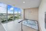 Recessed spa with metal handrail, full-height windows, neutral-toned wall finish, tiled flooring, and recessed ceiling lighting