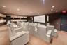 Dedicated media room with stadium-style seating, recessed ceiling lighting, a large projection screen, and wall-mounted speakers
