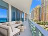 Expansive balcony featuring floor-to-ceiling sliding glass doors, a glass railing, and tiled flooring