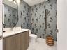 Wood-finish vanity with an integrated rectangular sink, wall-mounted oval mirror, and a three-light vanity fixture