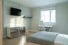 Room featuring wood-finish flooring, a wall-mounted floating storage unit with reflective finish, a fixed wall-mounted shelf, and a large window with 