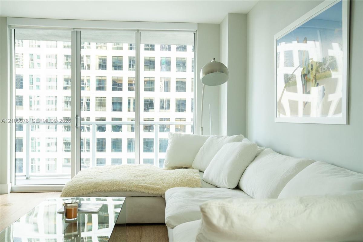 Living room with white sectional sofa and floor-to-ceiling windows