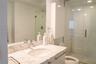 Bathroom featuring a stone-surface vanity with an integrated basin, wall-mounted medicine cabinet, full-width mirror, and a glass-enclosed walk-in sho
