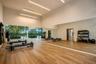 Fitness space featuring high ceilings, floor-to-ceiling mirrors, wood-finish flooring, linear LED lighting, and expansive glass window walls