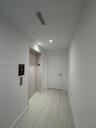 Neutral-toned hallway featuring wood-finish flooring, recessed ceiling lighting, and a private elevator entrance