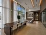 Floor-to-ceiling windows, stone tile flooring, recessed tray ceiling lighting, built-in wooden shelving, and wood-paneled walls