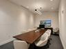 Interior room featuring linear LED pendant lighting, recessed ceiling lights, dark-toned carpet flooring, and a built-in dark wood console