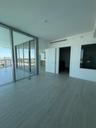 Floor-to-ceiling glass panel walls, light-toned wood-finish flooring, and recessed ceiling lighting