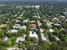 Aerial view of the property featuring a rectangular swimming pool, expansive green space, mature landscaping, and a multi-section roofline