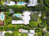 Aerial perspective of a low-density residential neighborhood characterized by mature tree canopy and established vegetation