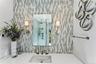Vertical mosaic tile backsplash, polished countertop with an integrated rectangular sink, wall-mounted brushed metal faucet, dual sconce lighting, and