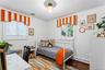 First Floor Bedroom  featuring wood-finish flooring, two dual-pane windows with integrated blinds, and a central glass globe light fixture