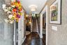Foyer featuring damask-patterned wallpaper, dark-toned stone floor tile, wood-finish flooring, and recessed ceiling lighting
