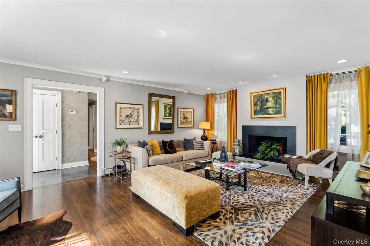 Living space featuring wood-finish flooring, a granite fireplace surround, recessed lighting