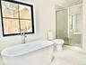 Bathroom with a freestanding tub, marble finish flooring, and plenty of natural light