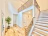 Stairway with a high ceiling, wood finished floors, and recessed lighting