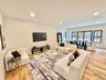 Living room with light wood-style flooring and recessed lighting
