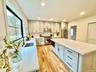 Kitchen with light stone counters, stainless steel appliances, tasteful backsplash, a center island, and recessed lighting