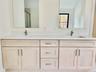Bathroom featuring double vanity and a shower stall