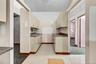 Kitchen featuring cream cabinets, dark countertops, and light carpet