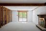 Interior space featuring exposed wood framing, painted masonry walls, a brick fireplace with a stone hearth, recessed lighting, and sliding glass door
