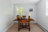 Neutral-toned interior space featuring light wood-finish flooring, two double-hung windows, and crisp white wall trim