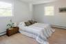 Neutral interior featuring light wood-finish flooring, two double-hung windows, and crisp wall paint