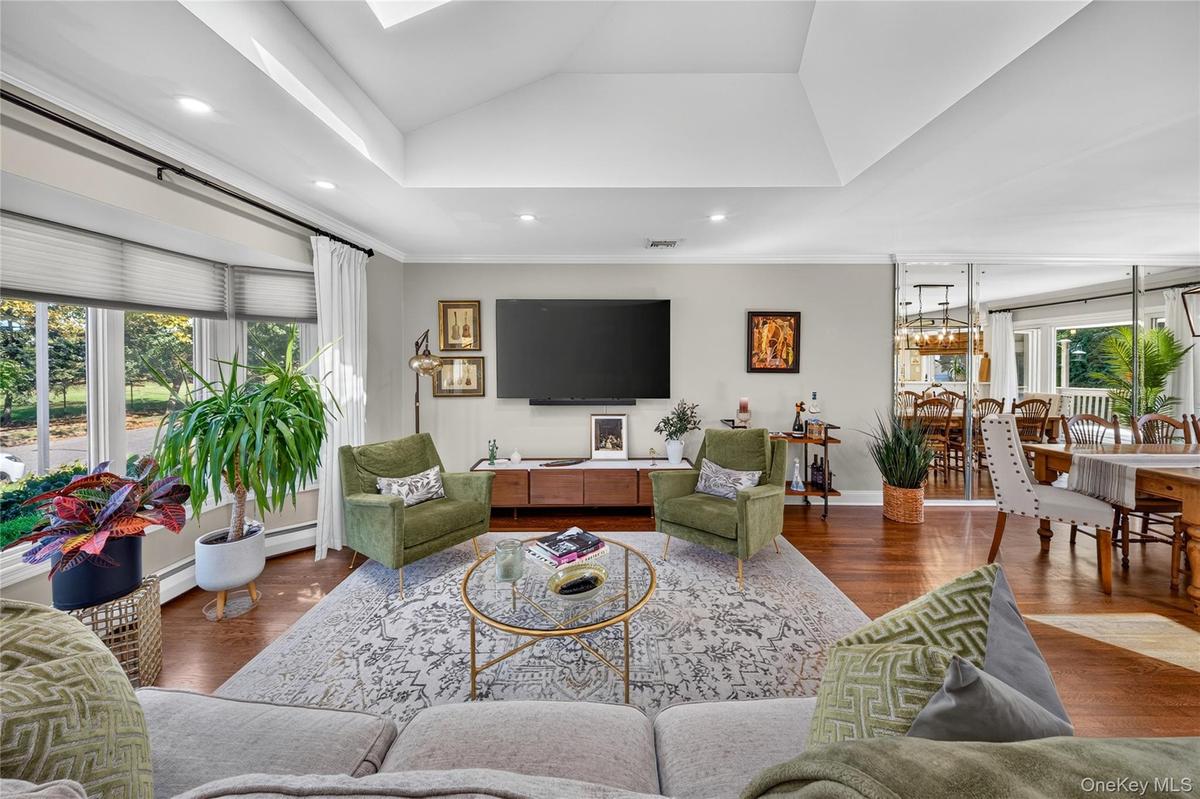 Vaulted ceiling, bay windows, recessed lighting, and wood-finish flooring